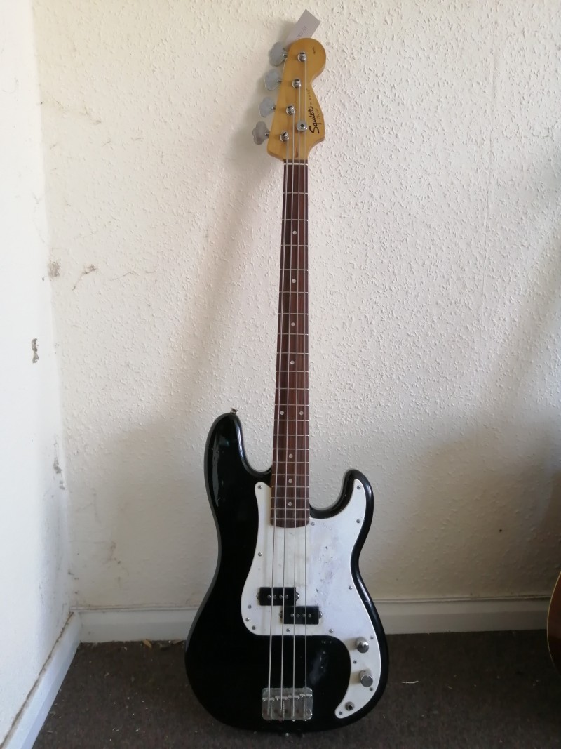 A Squier P-Bass guitar, a Harley Benton electric bass guitar, a Woodstock electro acoustic bass guitar and a Rocket 2013 bass guitar am